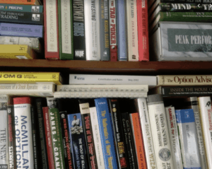 Närbild på Håkan Samuelssons bokhylla fylld med böcker om ekonomi, investeringar, aktiemarknaden och trading.